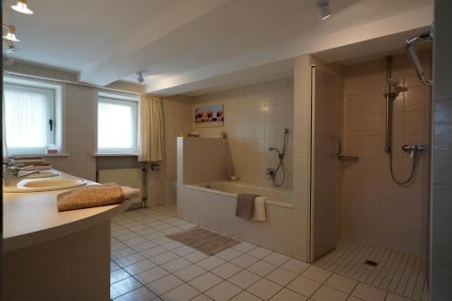 a bathroom with a tub and a shower and a sink at Ferienhaus Altes Wirtshaus in Lügde