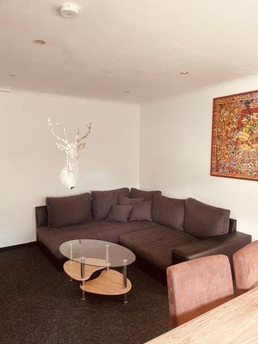 a living room with a brown couch and a table at Appartement Sabrina in Steinberg am Rofan