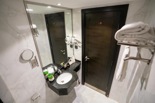 a bathroom with a sink and a toilet and a mirror at لمار أجياد الاول Tower A in Mecca