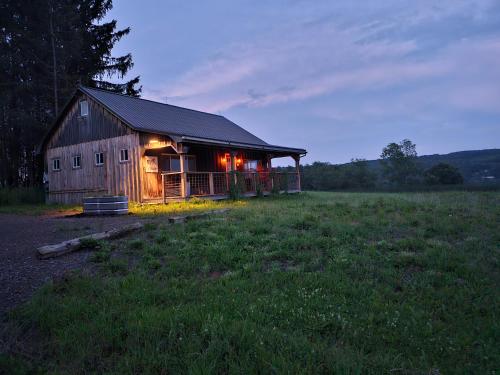 a barn with lights on in a field at Horse Farm Retreat in Sherburne