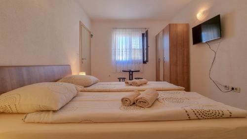 two beds in a room with towels on them at Lucijana Room in Novigrad Istria