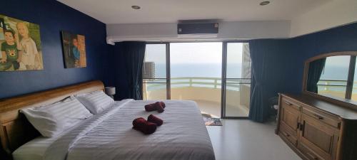 a bedroom with a bed with red shoes on it at VIP Condochain Rayong in Ban Chamrung