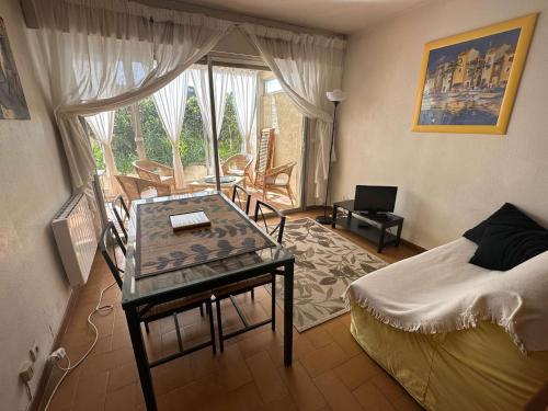 ein Schlafzimmer mit einem Bett und einem Tisch in einem Zimmer in der Unterkunft Grand T2 avec loggia et terrasse à proximité du port de Saint Mandrier et des plages in Saint-Mandrier-sur-Mer