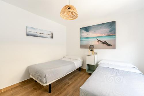 ein Schlafzimmer mit 2 Betten und einem Wandgemälde in der Unterkunft APARTAMENTO EN LA PLAYA DE BENIDORM in Benidorm