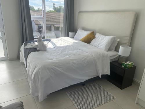 a bedroom with a large white bed with a window at 5 AntiP in Cape Town