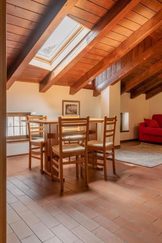 a living room with a table and chairs and a skylight at Hotel Diffuso Locanda Elisa in Dimaro