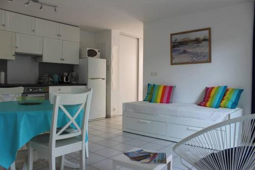 uma cozinha com uma cama, uma mesa e cadeiras em appartement cosy et nature au coeur du Bassin em Arès