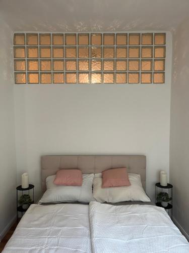 Una cama con dos almohadas rosas encima. en City Green Little Flat, en Budapest