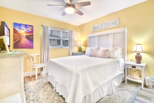 1 dormitorio con 1 cama blanca y ventilador de techo en Funshine Sunset Beach, en St Pete Beach