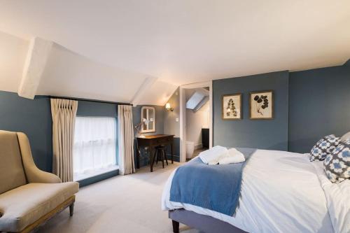 a bedroom with a bed and a chair and a desk at Great Escapes Oundle Flat 2 in Oundle