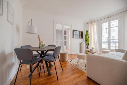 un salon avec une table, des chaises et un canapé dans l'établissement Nice Flat in Paris near Sacré Coeur, à Paris