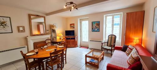 un salon avec une table et un canapé dans l'établissement Petite maison de village au cœur du village, à Saint-Clément-des-Baleines