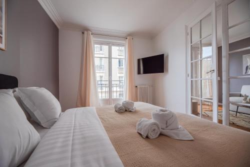 - une chambre avec des serviettes sur un lit et une fenêtre dans l'établissement Nice Flat in Paris near Sacré Coeur, à Paris