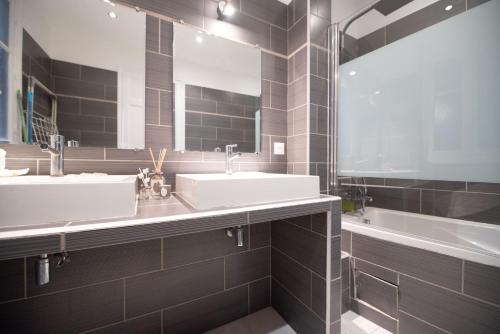 une salle de bain avec deux lavabos et une baignoire dans l'établissement Nice Flat in Paris near Sacré Coeur, à Paris