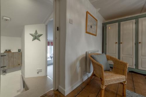 a living room with a chair and a star on the wall at Lovely Cottage in North Creake