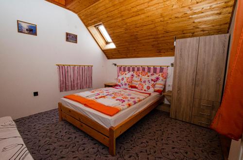 Habitación pequeña con cama y techo de madera. en Bánóporta, en Köveskál