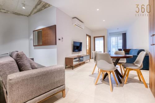 a living room with a couch and a table at The Swieqi Poolside Suites in Is-Swieqi