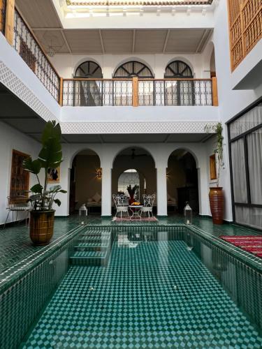 an indoor swimming pool with green tiles in a building at Riad Darchica in Marrakech