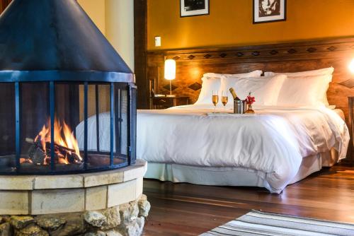 a bedroom with a bed with a fireplace at Maua Brasil Hotelaria in Visconde De Maua