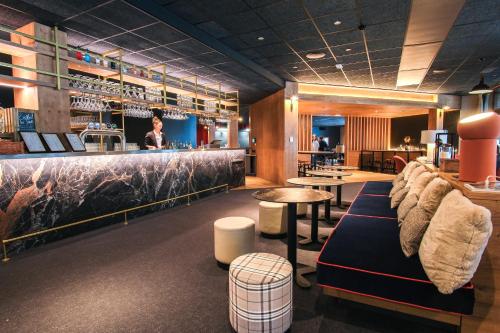 a restaurant with a bar with couches and tables at Belambra Clubs Flaine Panorama in Flaine