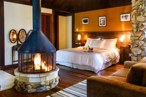 a hotel room with a bed and a fireplace at Maua Brasil Hotelaria in Visconde De Maua