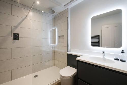a bathroom with a sink and a toilet and a mirror at Great Escapes Oundle Flat 1 in Oundle