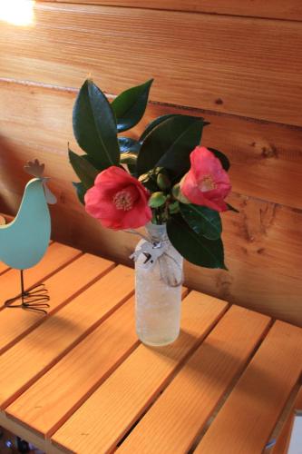 a vase with flowers sitting on a wooden table at Casa da Avó Miquinhas in Paços de Ferreira