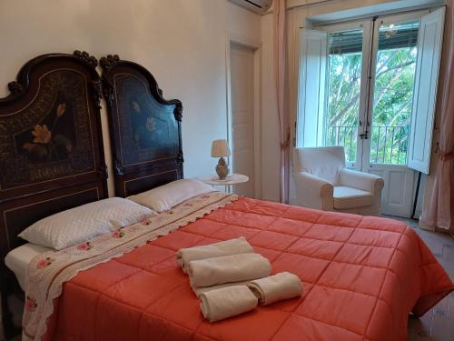ein Schlafzimmer mit einem großen orangenen Bett mit zwei Handtüchern darauf in der Unterkunft Il Giardino Segreto B&B in Trappitello