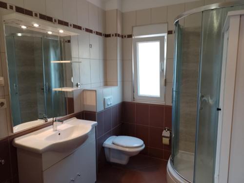 a bathroom with a sink and a toilet and a shower at Apartments Silvije in Marina