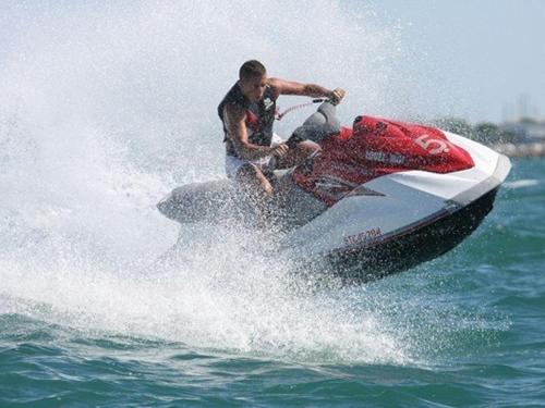 un homme faisant du jet ski dans l'eau dans l'établissement Appartement 2P avec terrasse, garage, 250m plage, 4 pers, WiFi optionnel - FR-1-307-165, au Grau-du-Roi