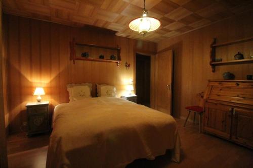 ein Schlafzimmer mit einem Bett, einer Kommode und Lichtern in der Unterkunft Chalet Privé avec vue imprenable sur les alpes in Crans-Montana
