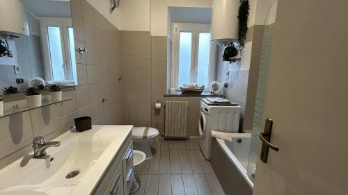 La salle de bains blanche est pourvue d'un lavabo et de toilettes. dans l'établissement Ankon Apartment La Casa di Joye & Nemi, à Ancône