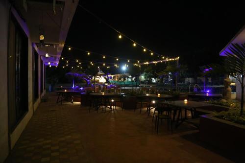a patio with tables and lights at night at Suryaansh in Pālghar