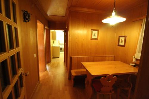 a dining room with a wooden table and a hallway at Chalet Privé avec vue imprenable sur les alpes in Crans-Montana