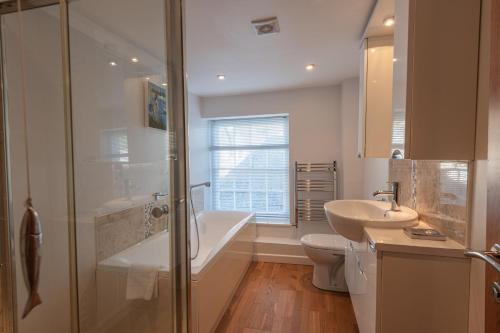 a bathroom with a tub and a sink and a toilet at Quayside, Fowey in Fowey