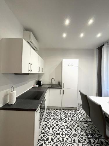 - une cuisine avec des placards blancs et un sol noir et blanc dans l'établissement Home Sweet Home - Stephansdom, à Vienne