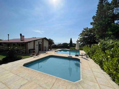 una piscina en un patio junto a una casa en Casa pé na areia em praia paradisíaca com piscina frente mar, en Balneário Camboriú