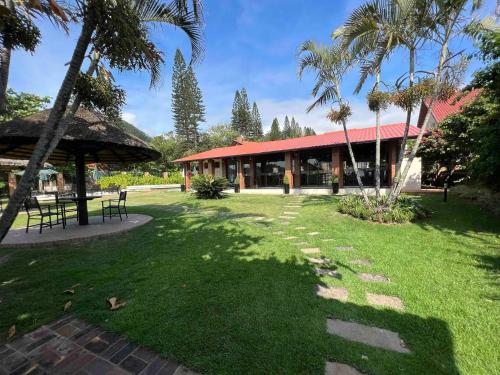 een park met een gebouw met palmbomen en gras bij Casa pé na areia em praia paradisíaca com piscina frente mar in Balneário Camboriú