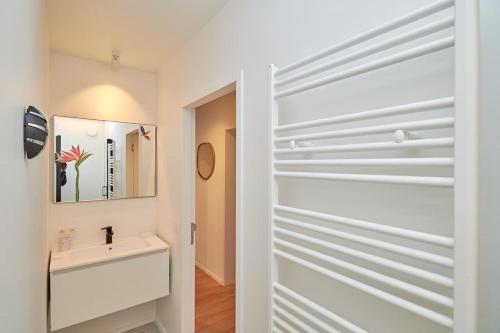 La salle de bains est pourvue d'une porte coulissante menant à un lavabo. dans l'établissement Saint Tropez 0202, à La Panne