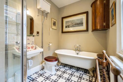 a bathroom with a tub and a toilet and a sink at The Victorian House in York