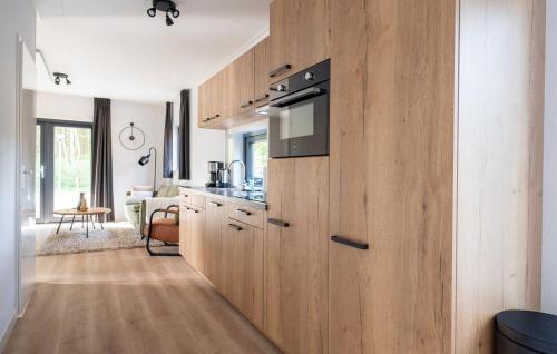 a kitchen with wooden cabinets and a stove top oven at Schitterend gelegen luxe ingericht 6 persoons chalet met hottub aan de bossen in Putten 4-15 in Putten