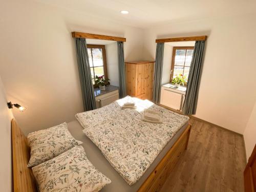 a bedroom with two beds and two windows at Apartment House Prezlc in Kranjska Gora
