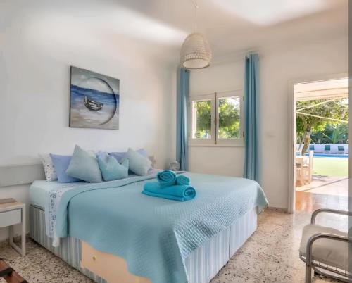 Un dormitorio con una cama con una toalla azul. en Tropical Oasis Villa Playa Paraiso, en Playa Paraiso