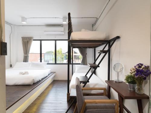 a bedroom with two bunk beds and a desk at SHIN Hotel Nimman ChiangMai in Chiang Mai