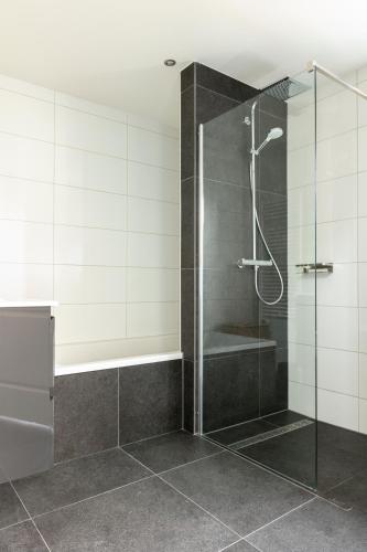 a shower with a glass door in a bathroom at Luxe vakantiebungalow casa Cranenweyer in Kerkrade