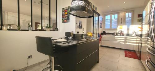 une cuisine avec un comptoir noir et un évier dans l'établissement Konforta : Paisible maison d'été avec grand jardin, à Sainte-Geneviève-des-Bois