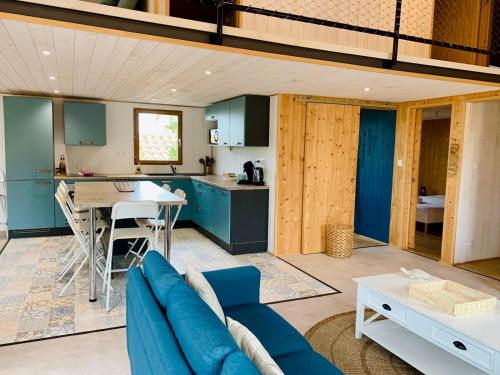 un salon avec un canapé bleu et une cuisine dans l'établissement La cabane Sètoise, à Sète