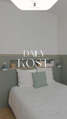 a bedroom with a white bed with a sign above it at Daily Kost @Pontianak City Center in Siantan