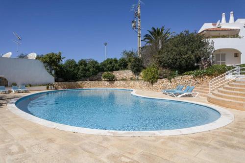 The Albufeira Concierge - Villa Pool & Tennis في Galé: حمام سباحة مع كرسيين ومنزل