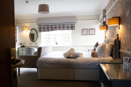 sypialnia z dużym białym łóżkiem i oknem w obiekcie The Broadoak w mieście Ashton under Lyne